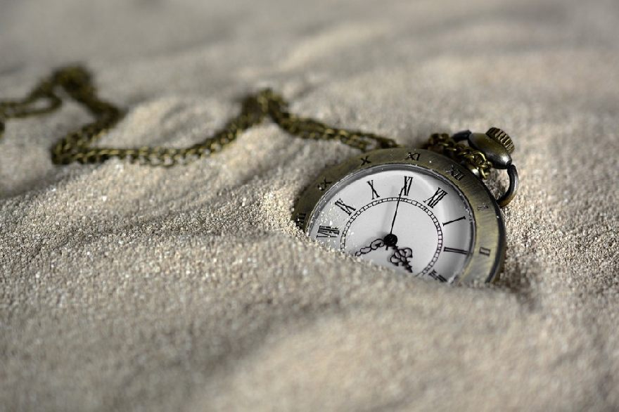 Taschenuhr im Sand.